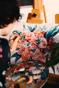 woman painting roses on a canvas